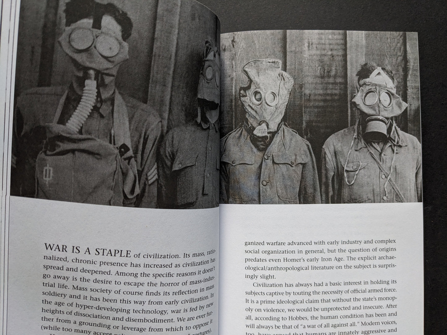 Spread from A People’s History of Civilization – historical photograph of soldiers in gas masks with essay on war and civilization