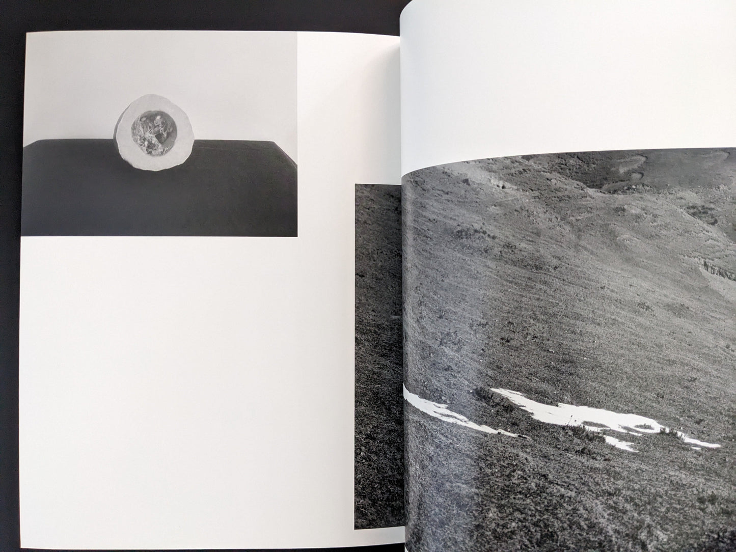 Page from Ash (New Edition) by Muge, close-up black-and-white photograph of textured rock surfaces.