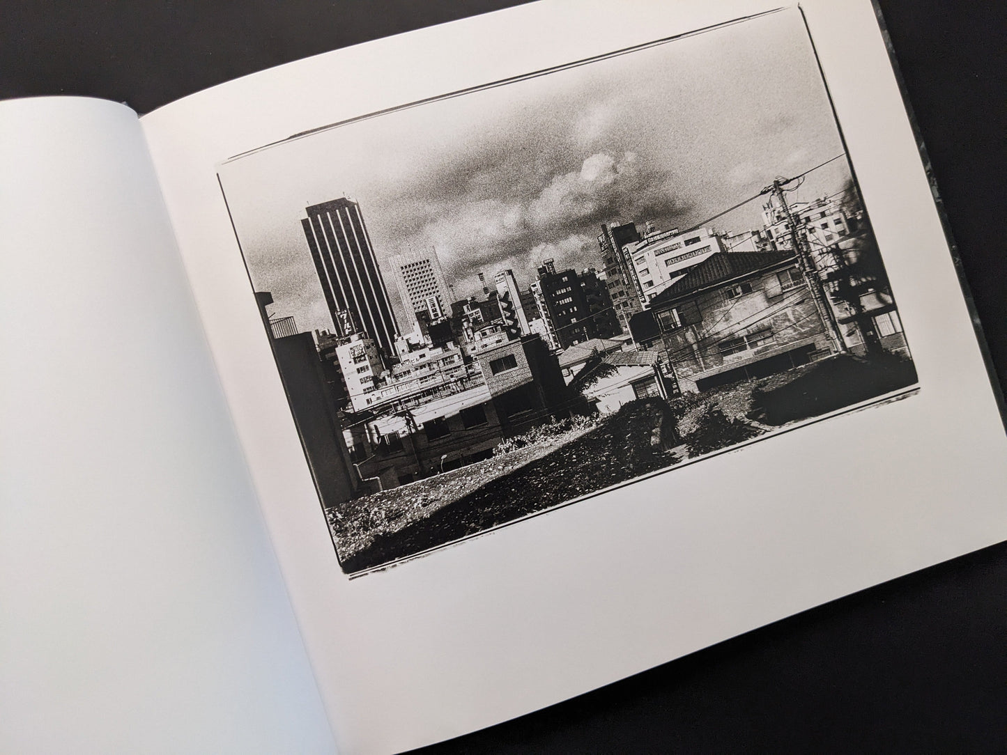 Urban landscape photograph from 1980s Remnants by Daido Moriyama with high-rise buildings and open lot