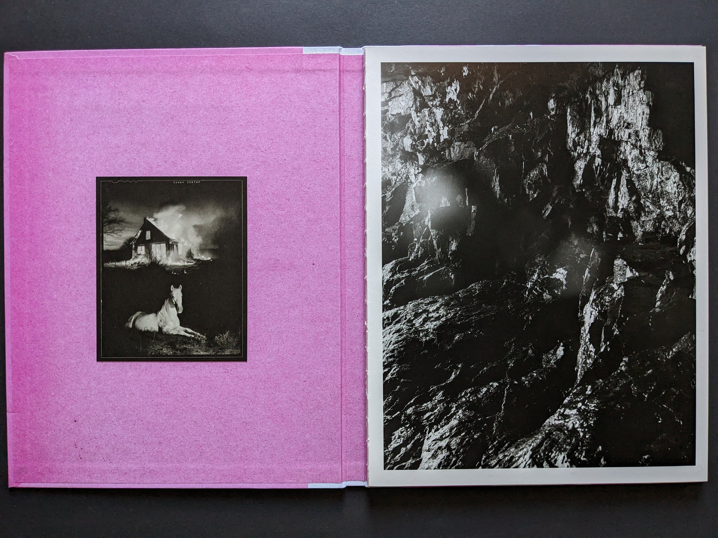 Inside cover of "Flowers Drink the River" showing a burning house and a white horse on the left, and a black-and-white photograph of a cave on the right.