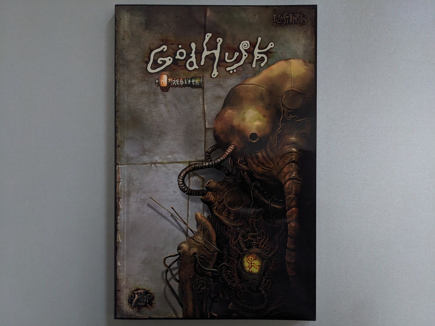 Front cover of Godhusk – rebirth by Plastiboo featuring grotesque biomechanical figure