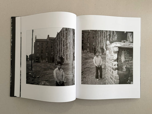 Open book spread from Gorbals by Peter Christopherson, showing two black-and-white photographs of a boy in a derelict urban setting.