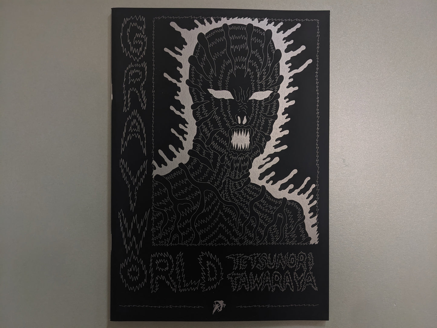 Front cover of Grayworld by Tetsunori Tawaraya with silver ink drawing of alien figure on black background.