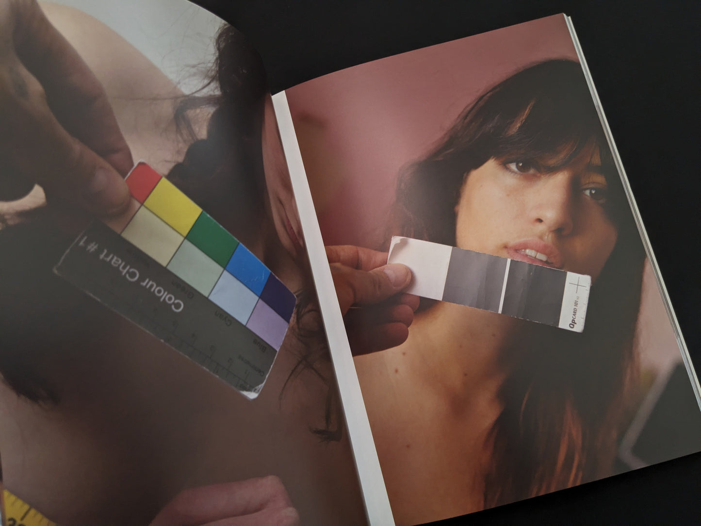 Portrait of a young woman holding a colorful chart for color calibration, from "Grey Cards" by Richard Kern.