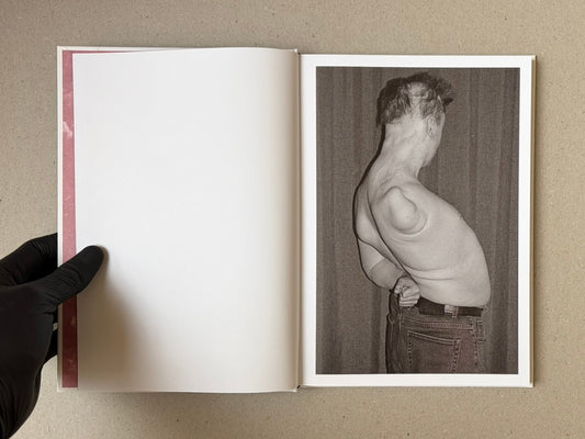 Open spread of Gut Feeling by Kristina Rozhkova, with a black-and-white photograph on the right page and a blank left page with a pink inner margin.