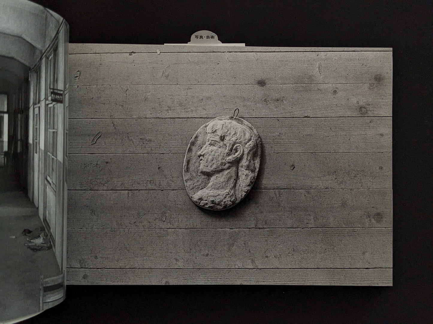 Wall-mounted sculpture of a head in the ruins of Hashima Island
