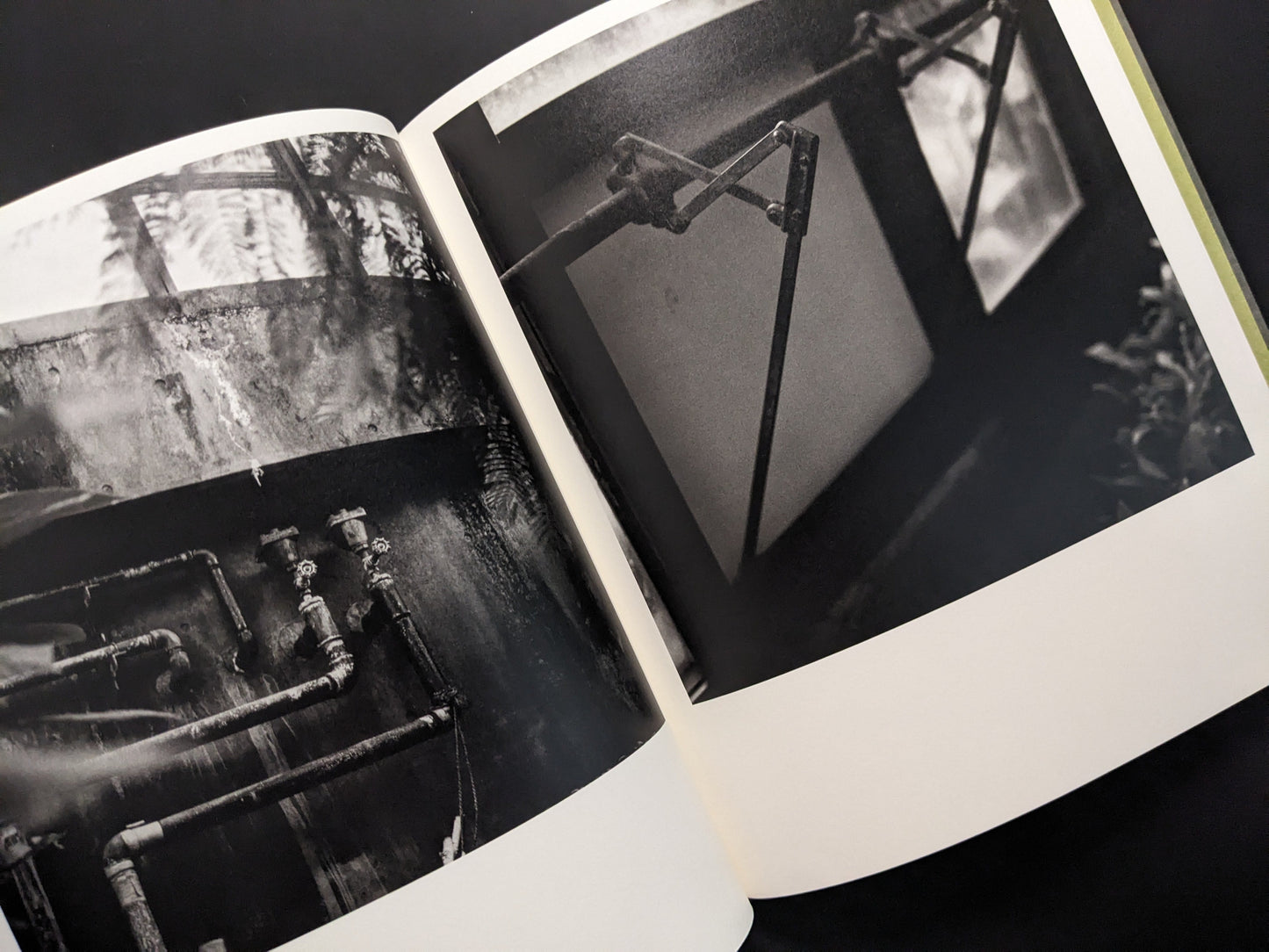 Industrial pipes and mechanical window opener inside a greenhouse, photographed in black and white by Takeshi Shinoda.
