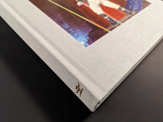 Clothbound spine detail with small stamped logo; slight corner bump visible.