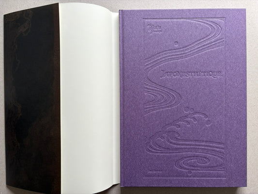 Japonesthétique by Takato Yamamoto opened to the purple embossed cover and front endpaper.