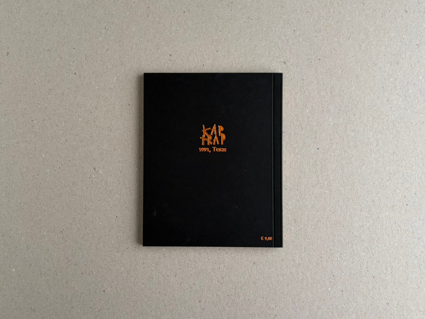Back cover of KAP TRAP with gold foil illustration on a black background.
