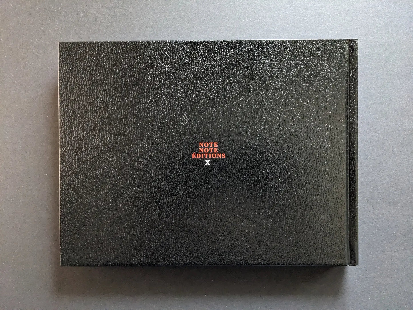 Back board of Keep Distance photobook by Boris Mikhailov, black faux-leather cover with small Note Note Éditions logo.