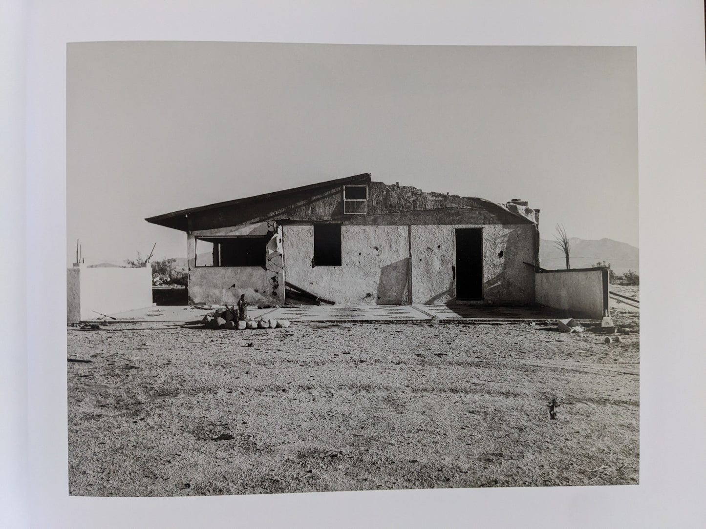 Ruined desert house with broken windows from Mark Ruwedel's "Message from the Exterior"