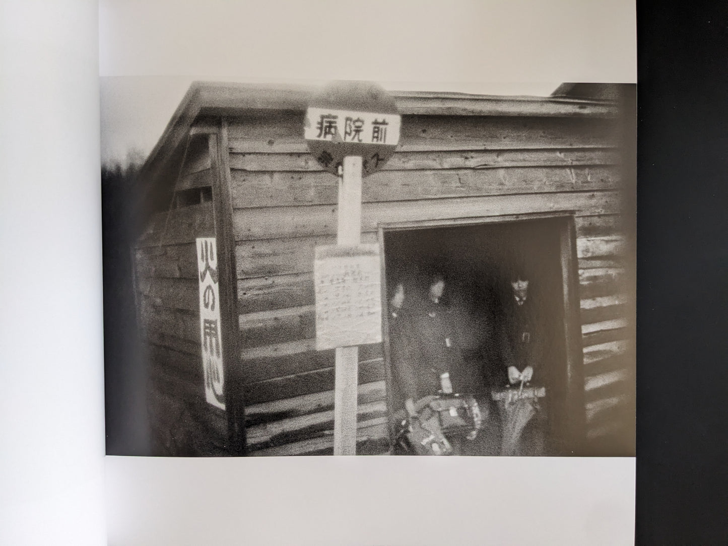 Black-and-white photograph of people standing in the doorway of a wooden building.