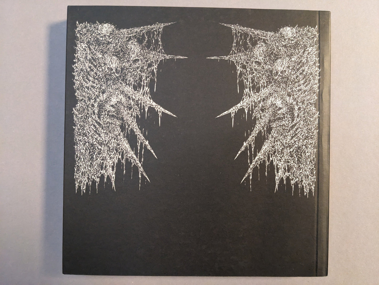 Back cover of Manifester Monsters art book by Mat Brinkman with silver printed artwork