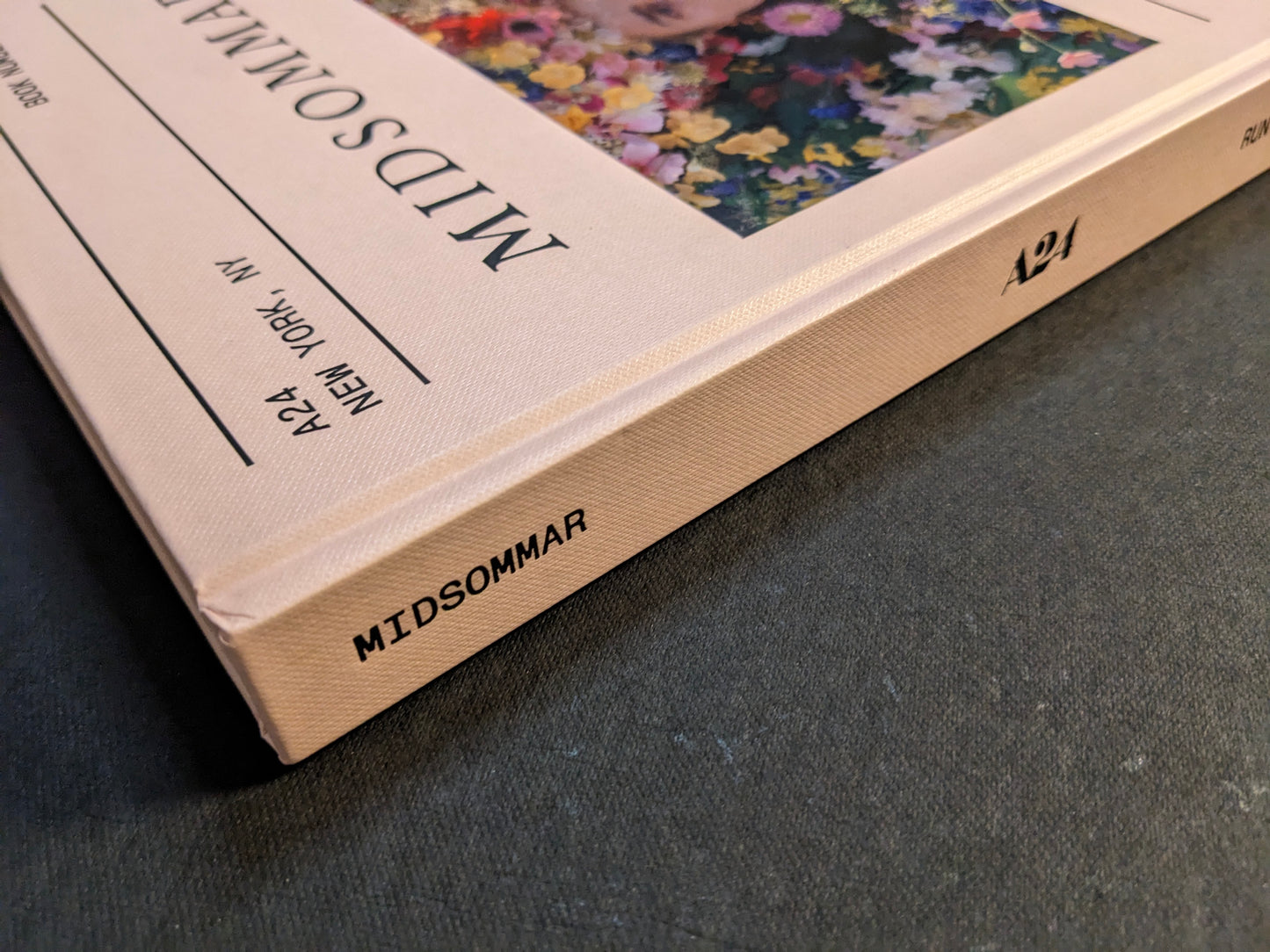 Close-up view of the spine and clothbound corner of the Midsommar screenplay book by Ari Aster.