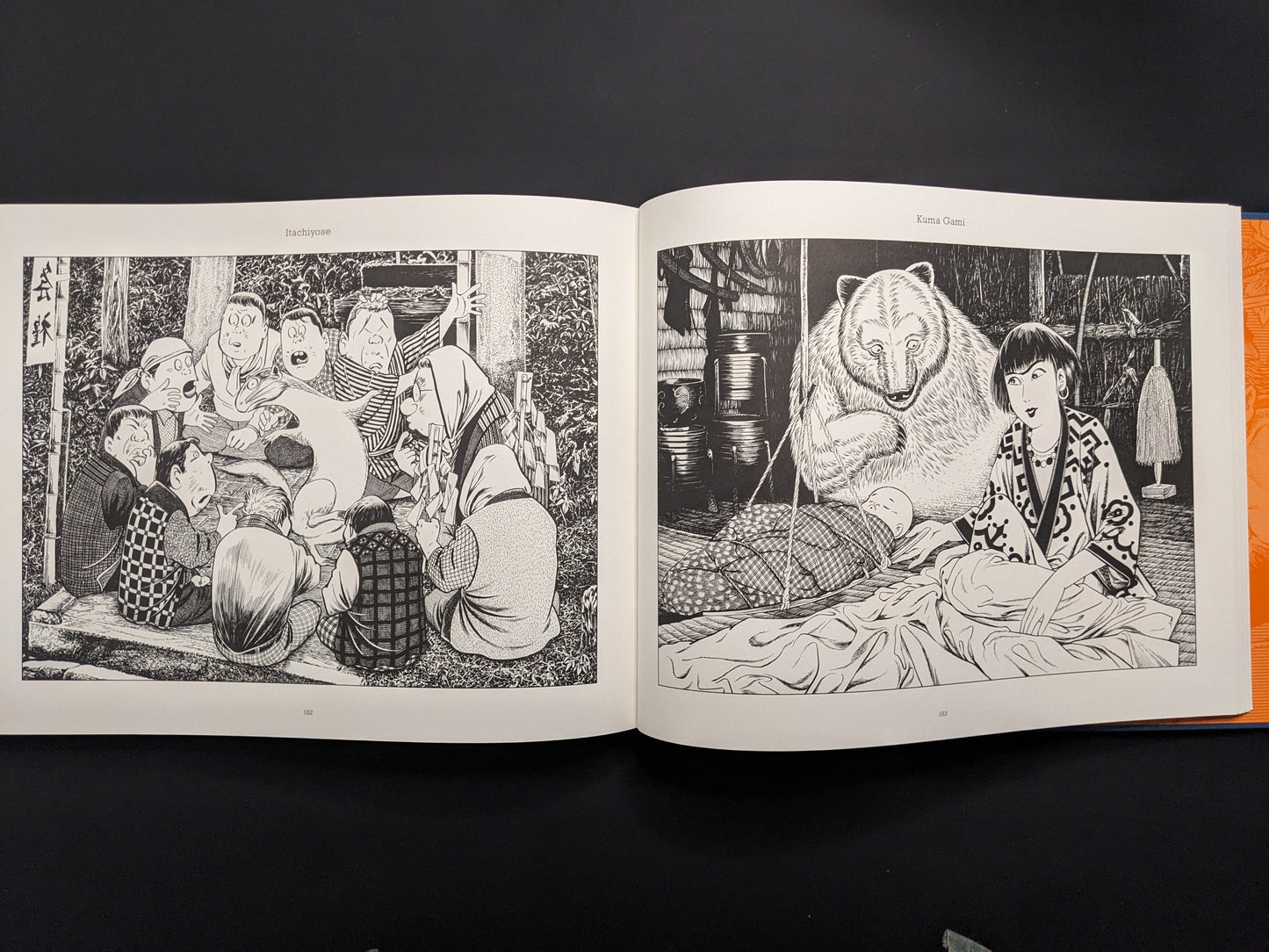 Open book displaying black and white illustrations on a dark background