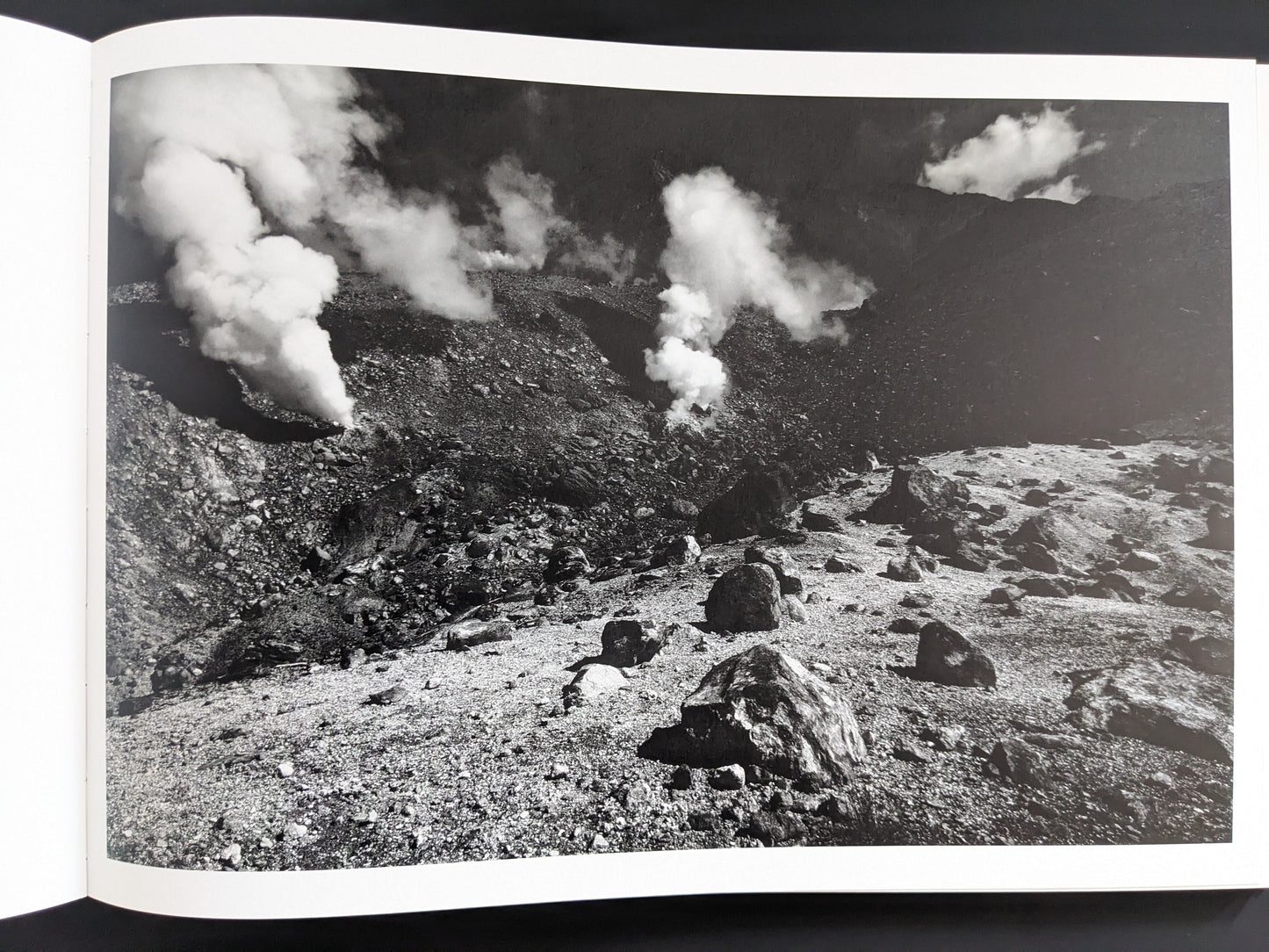 Black and white image of steaming vents in rocky terrain, New Land