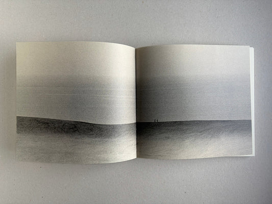 Nusa by Masao Yamamoto, open spread with a wide landscape photograph