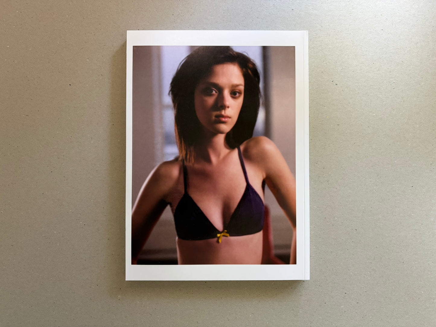 Portrait-format page with a woman in a black bra, shown against a soft indoor background.