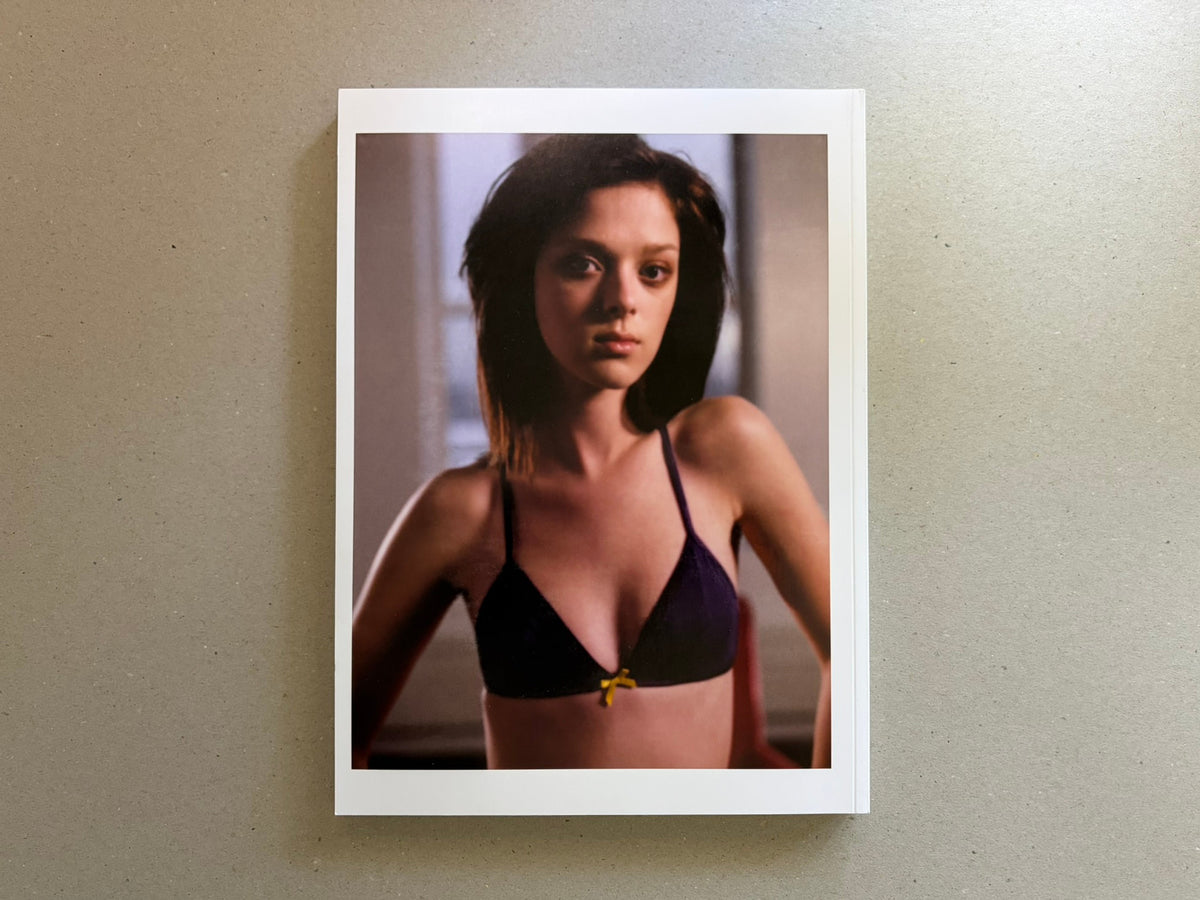 Portrait-format page with a woman in a black bra against a soft indoor background.