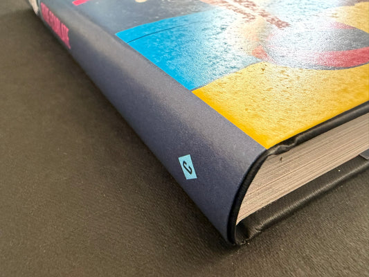 Close-up of the lower spine and page block of Rêve écarlate