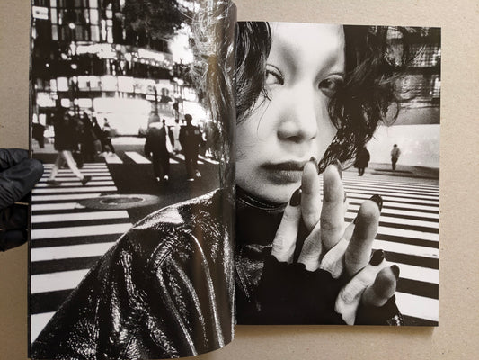 Double-exposure spread with a city crosswalk and close-up portrait, Record No. 50 by Daido Moriyama.