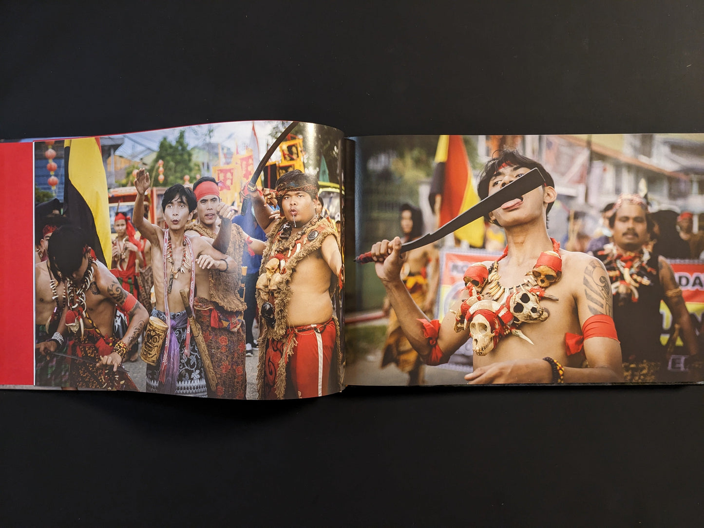 Ritual procession of Tatung participants in Borneo, wearing traditional attire and performing self-mortification with knives.