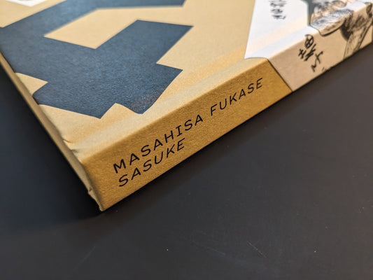 Book spine of Masahisa Fukase “Sasuke” with title lettering on gold hardcover, Akaaka Art Publishing (2021).