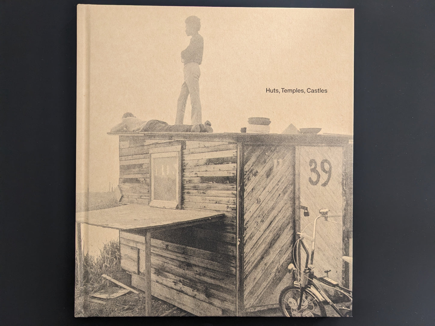 Front cover of Huts, Temples, Castles by Ursula Schulz-Dornburg – children standing on a self-built hut