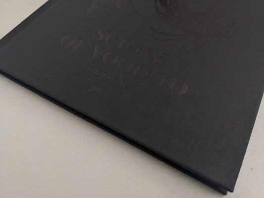 Close-up of black canvas hardcover with embossed title – Scions of Voodoo