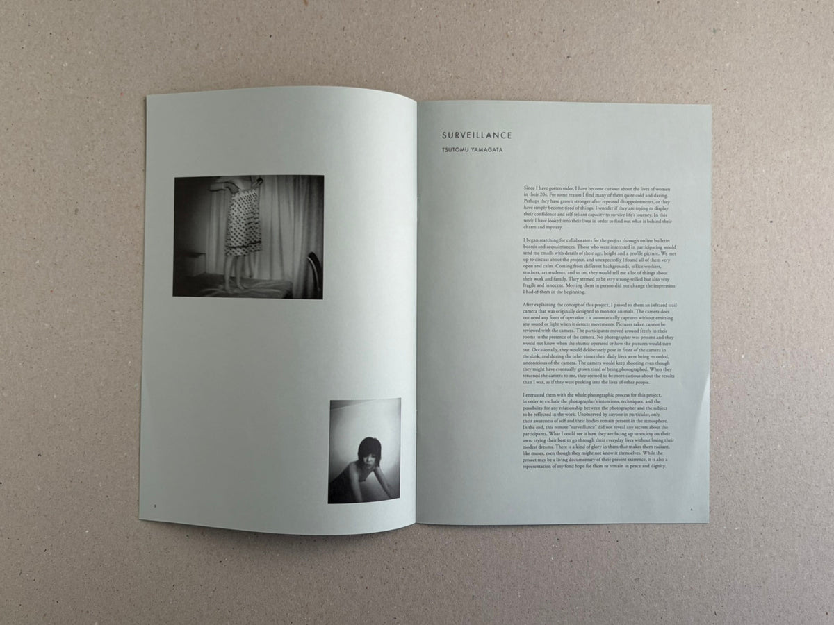 Open spread of Surveillance by Tsutomu Yamagata, showing two black-and-white photographs on the left page and a text page on the right.