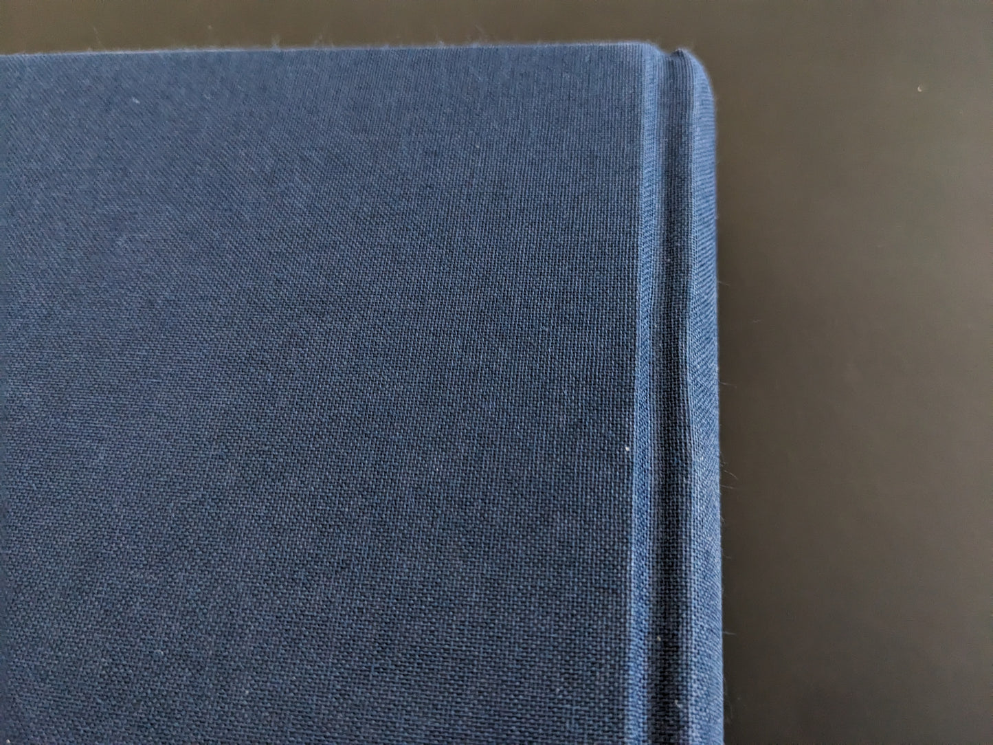 Cloth spine joint of the book with visible signs of use