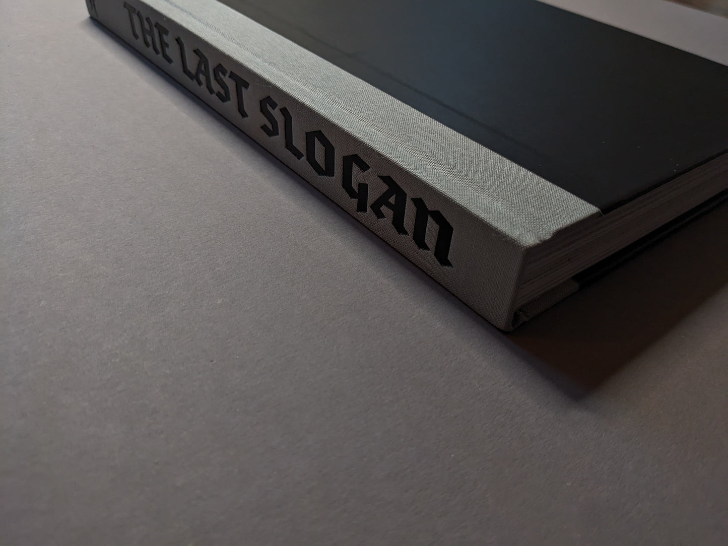 Book spine with title 'The Last Slogan' in gothic typeface