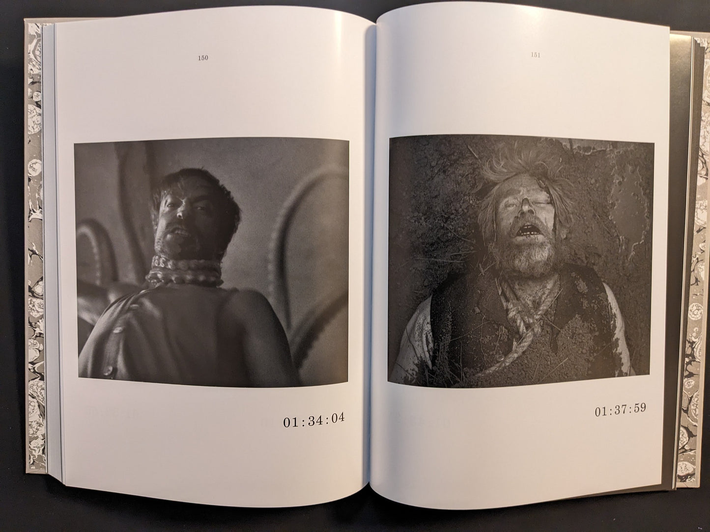 Double-page spread from The Lighthouse Screenplay Book featuring black-and-white stills of Robert Pattinson and Willem Dafoe.