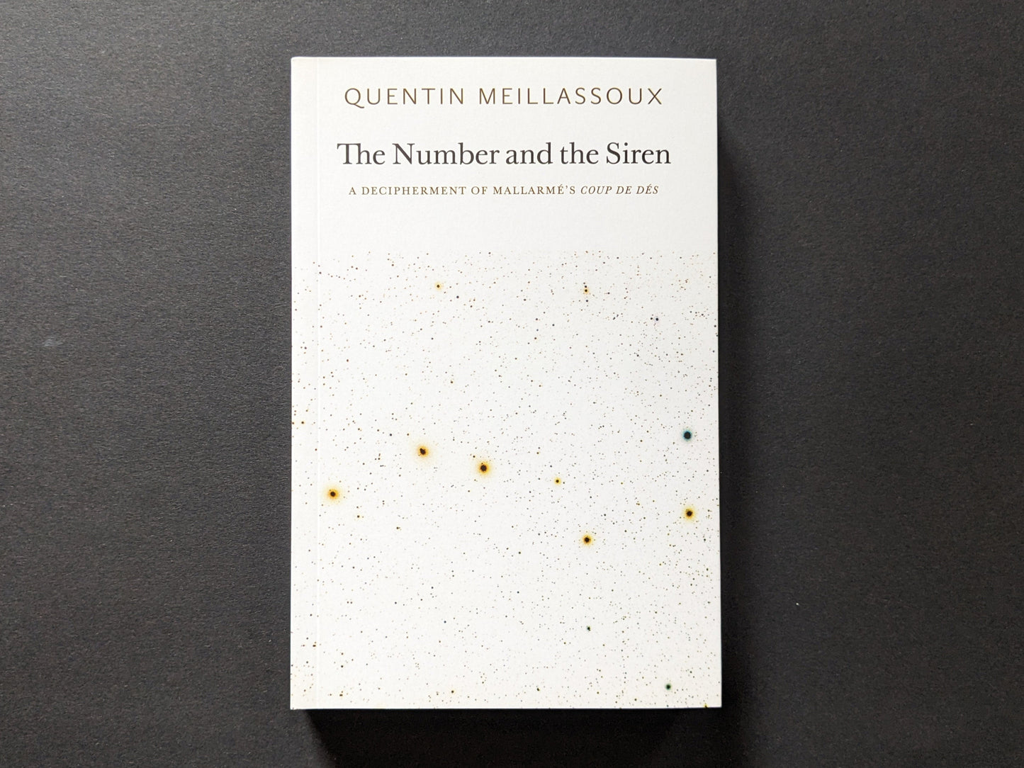 Front cover of The Number and the Siren by Quentin Meillassoux, featuring a minimalist white background with specks of color resembling a cosmic design.