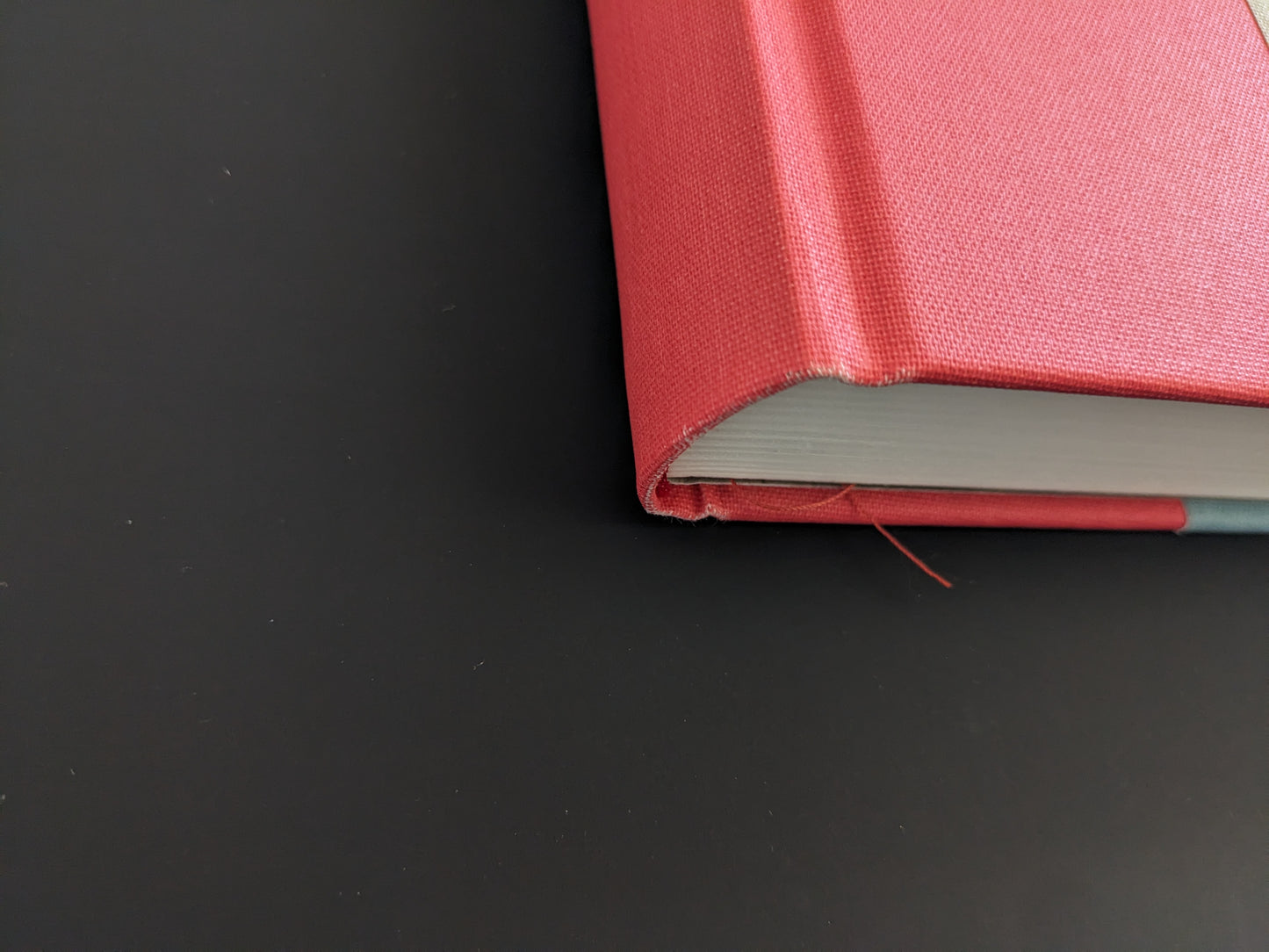 Close-up of book spine corner of The Pillar by Stephen Gill, red cloth binding with visible wear and fraying