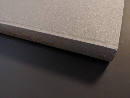Book spine of The Universe is a Haunted House with gold embossed text on grey cloth cover.