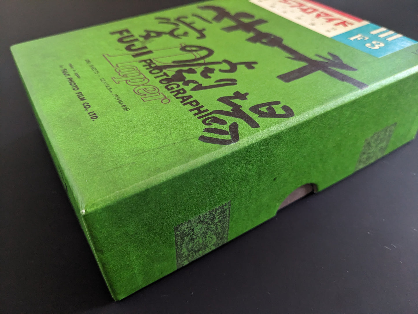Detail shot of the green Fuji photographic paper box used as the packaging for 'Theater of Love' by Nobuyoshi Araki