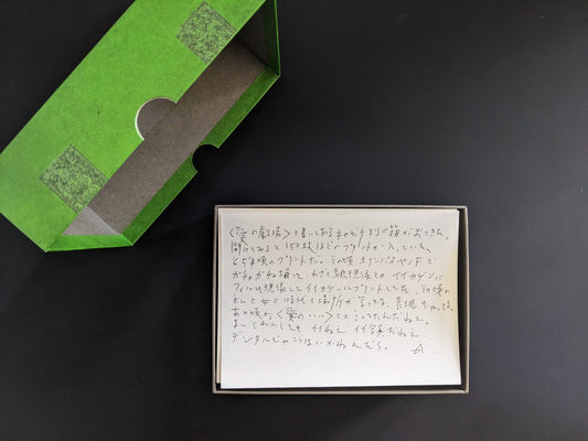 Open green box with a handwritten note and the Theater of Love print set inside