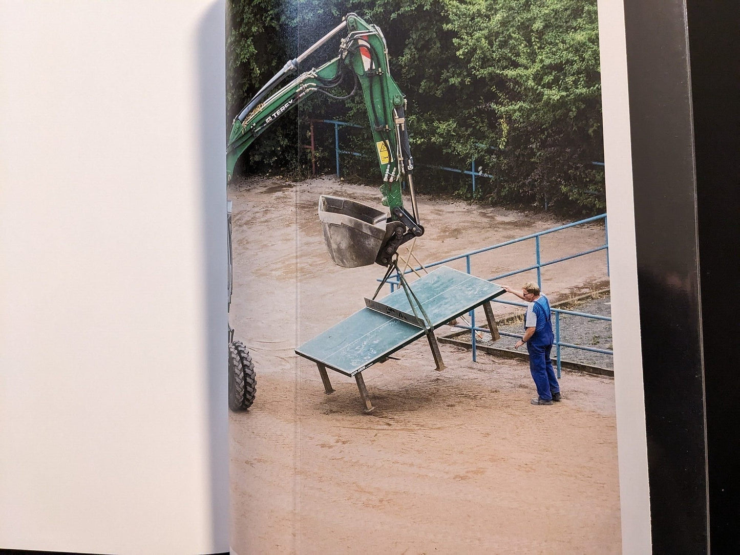 Photograph from TTP by Hayahisa Tomiyasu showing a construction machine lifting the ping pong table.