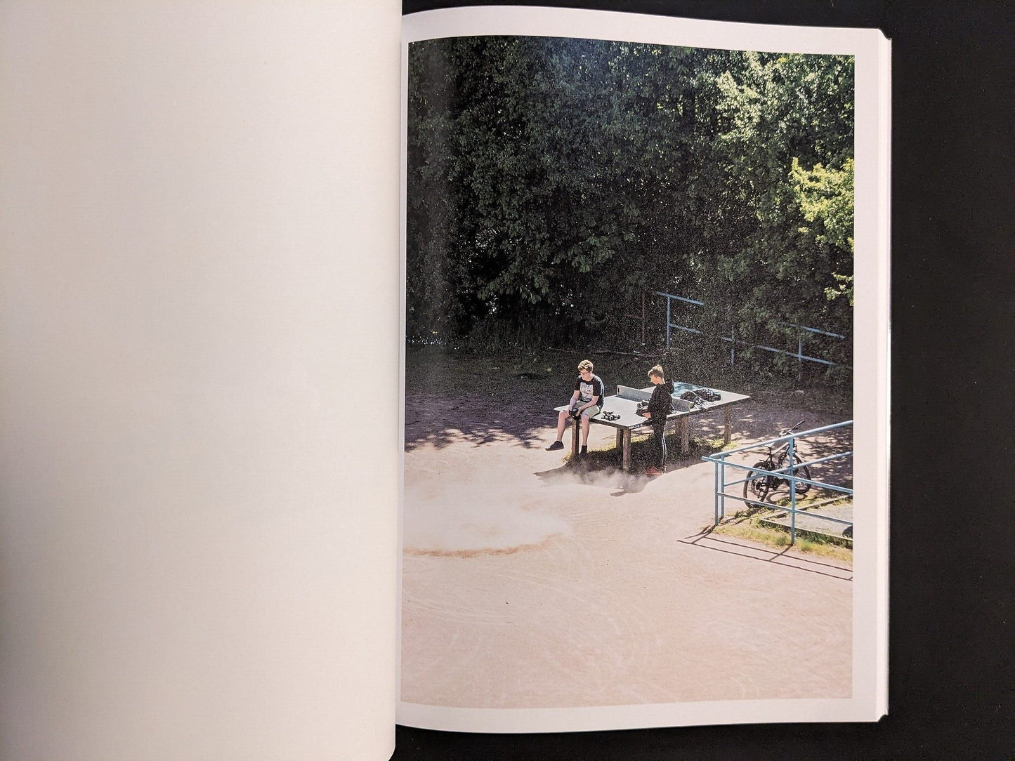 Photograph from TTP by Hayahisa Tomiyasu showing two boys playing near the table on a dusty field.