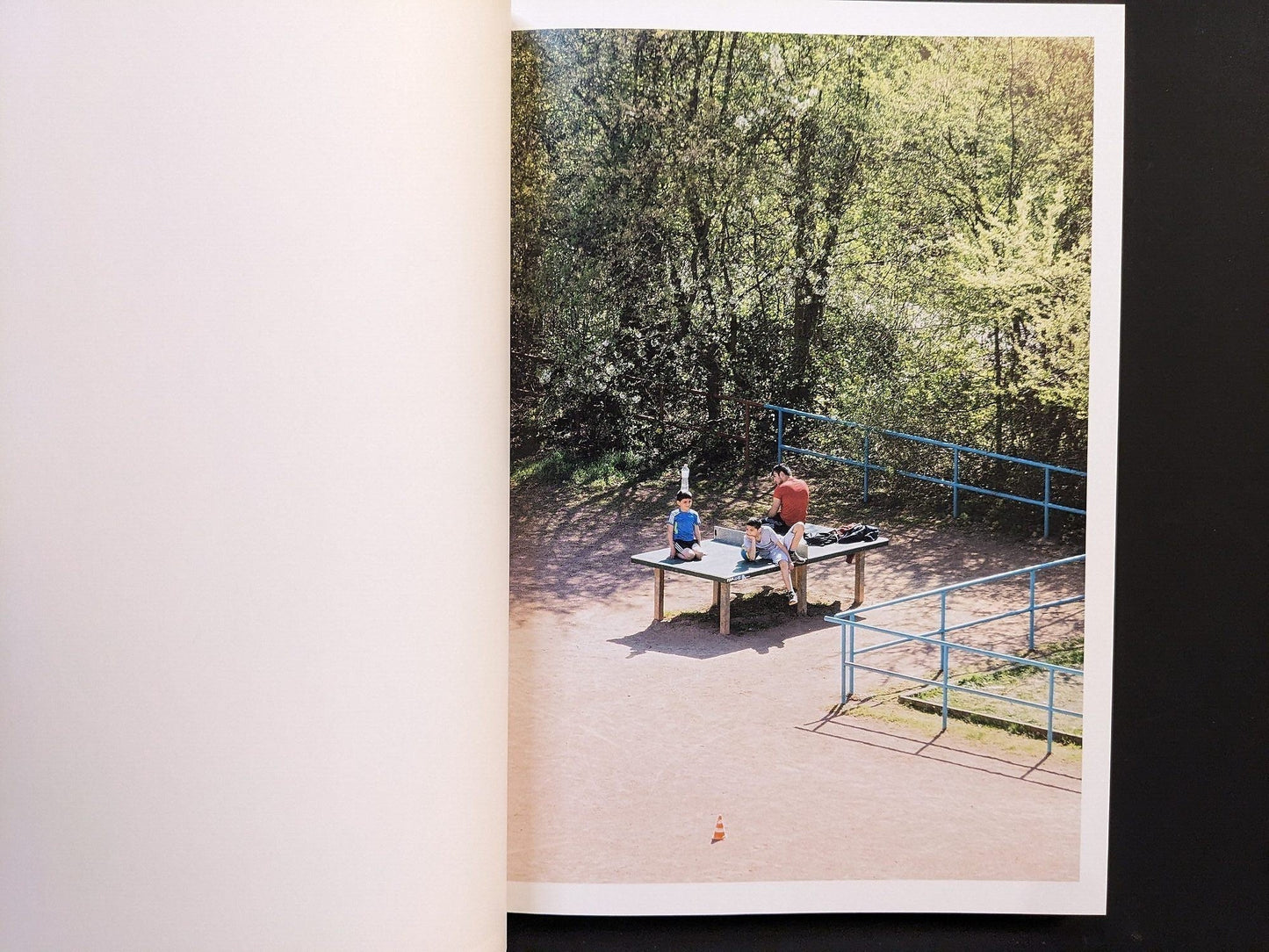 Photograph from TTP by Hayahisa Tomiyasu capturing people at the ping pong table under bright summer light.
