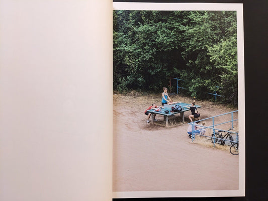 Interior spread from TTP by Hayahisa Tomiyasu, showing people resting around a ping pong table in Leipzig.