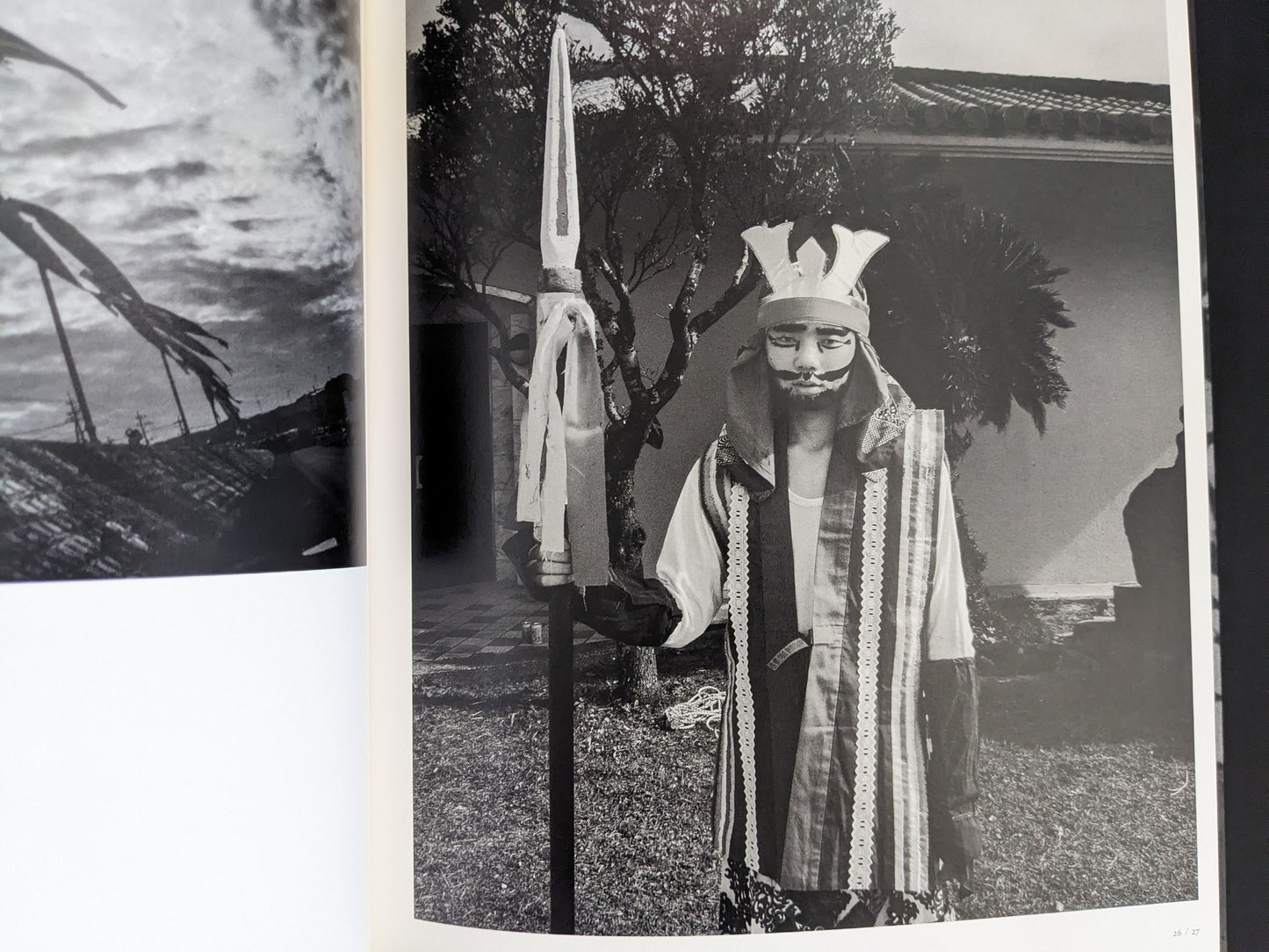 Black and white photo of masked performer holding spear in Wandering Dog