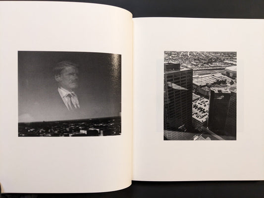 Interior spread from i shall sing these songs beautifully showing portrait and aerial city photograph in black and white.