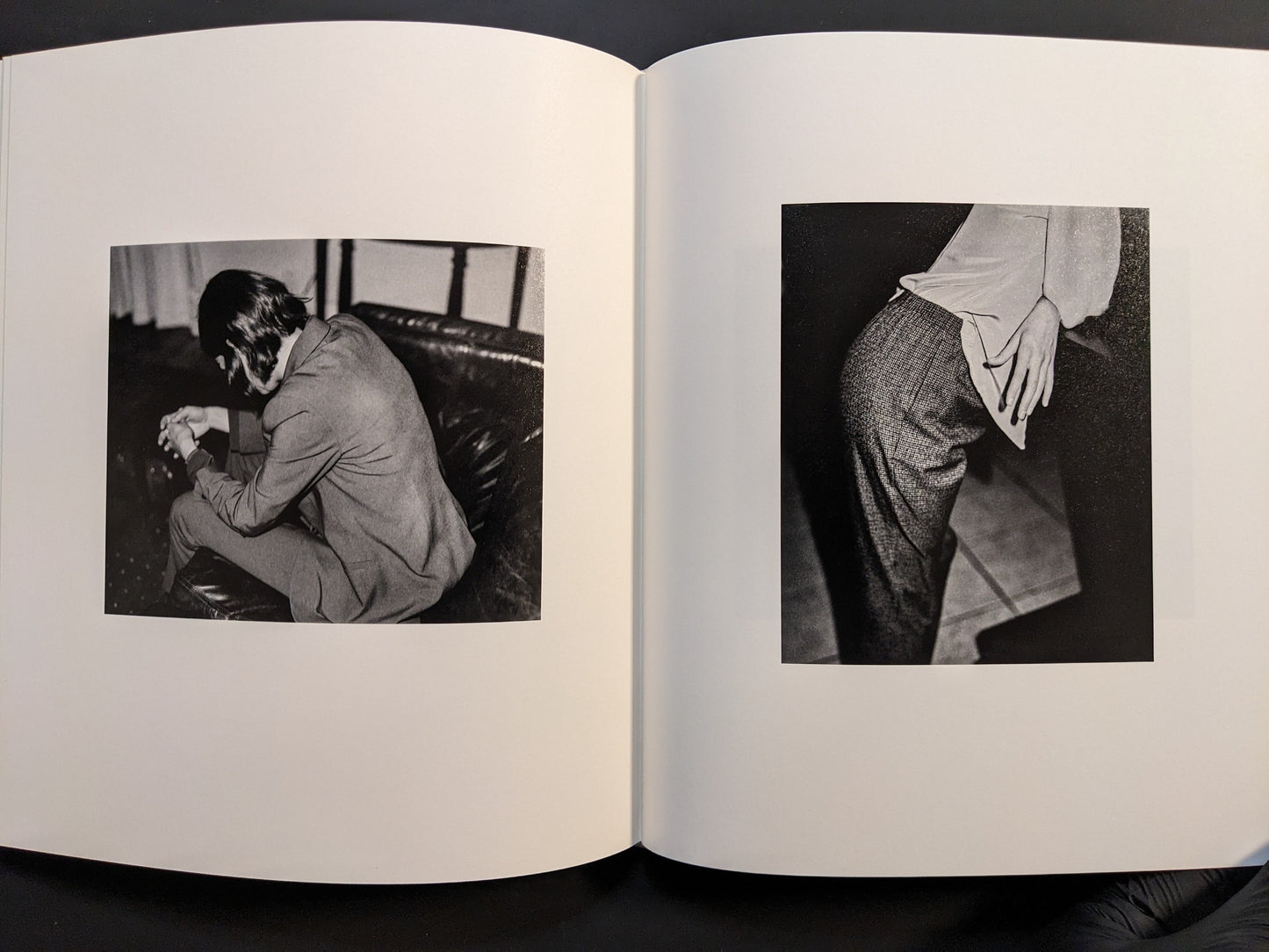 Interior spread featuring two black-and-white photographs — one of a seated man and one showing a close-up of a hand on fabric.