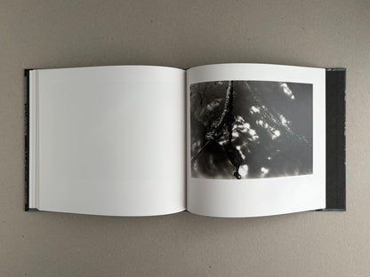 Open hardcover book showing a blank left page and a black-and-white photograph on the right page from 1980s Remnants by Daido Moriyama.