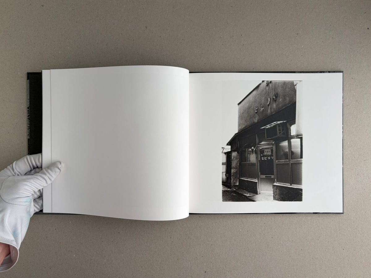 Open spread of 1980s Remnants by Daido Moriyama, with a black-and-white photograph printed on the right page and a blank left page.