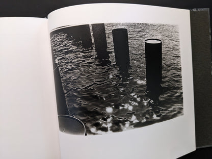 Experimental black and white photo of water reflections and columns by Daido Moriyama