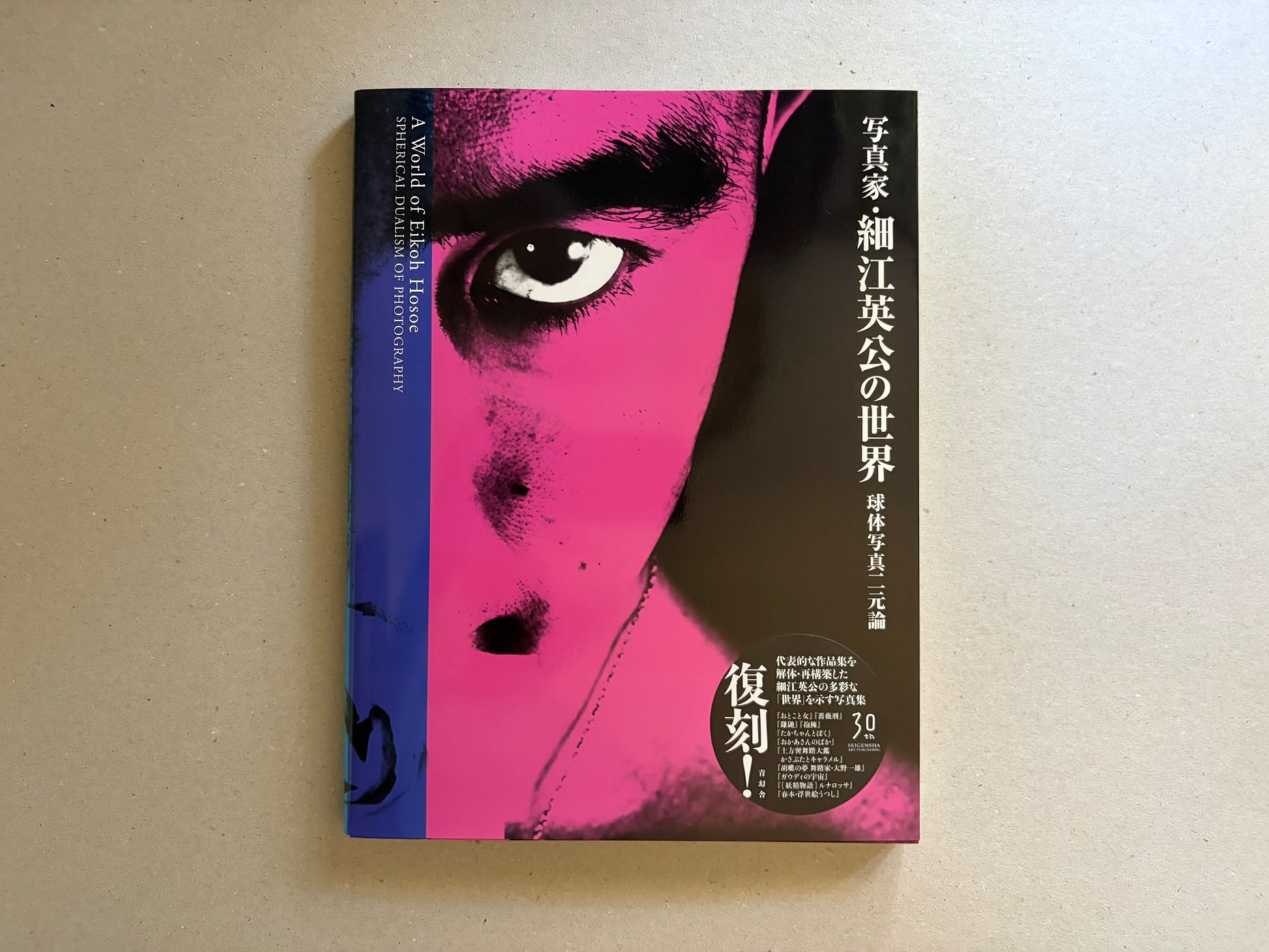 A World of Eikoh Hosoe: Spherical Dualism of Photograph, front cover on a beige surface, with a close-up pink-and-black face and vertical Japanese title.